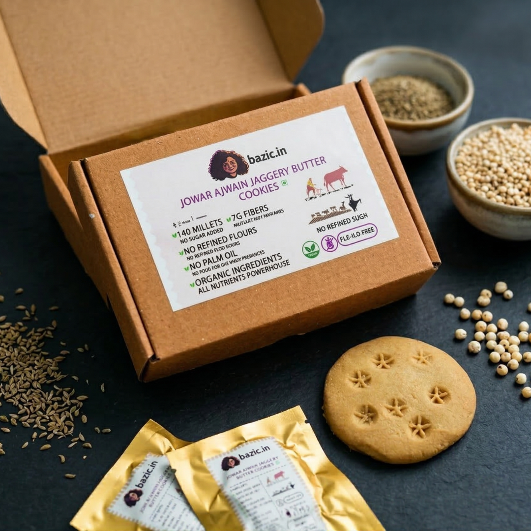 Bazic gluten-free millet butter cookies in black bowl with jaggery and jowar — overhead flat lay on brown background