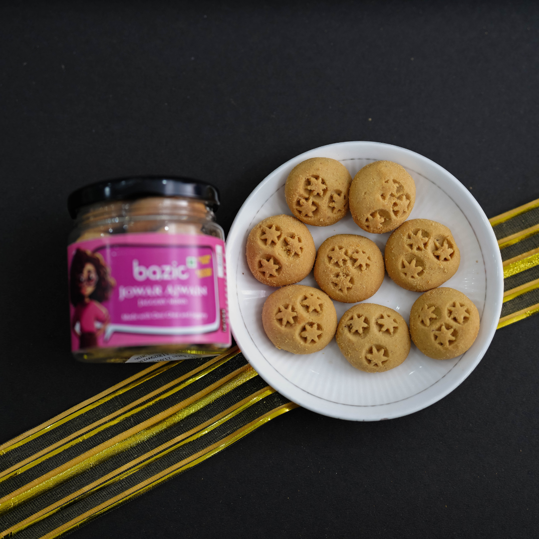 Bazic mini cookie ingredients — jowar flour, jaggery, butter and carom seeds styled on cloth